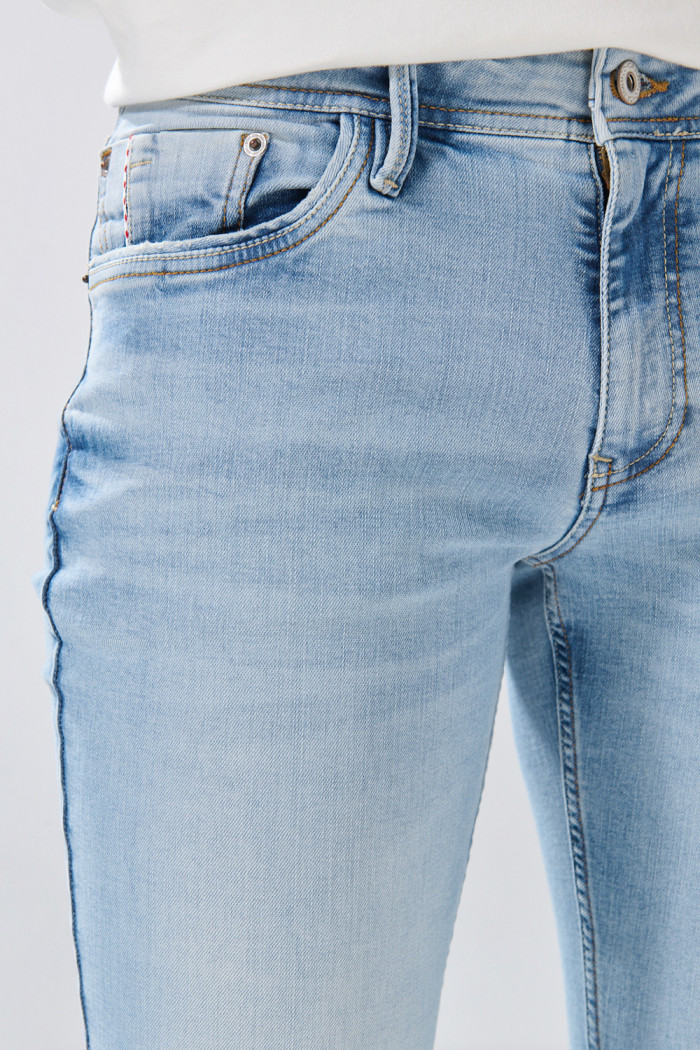 Jean skinny tiro bajo azul con desgastes y cremallera
