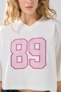 Camiseta crema oversize crop top college con cuello V

