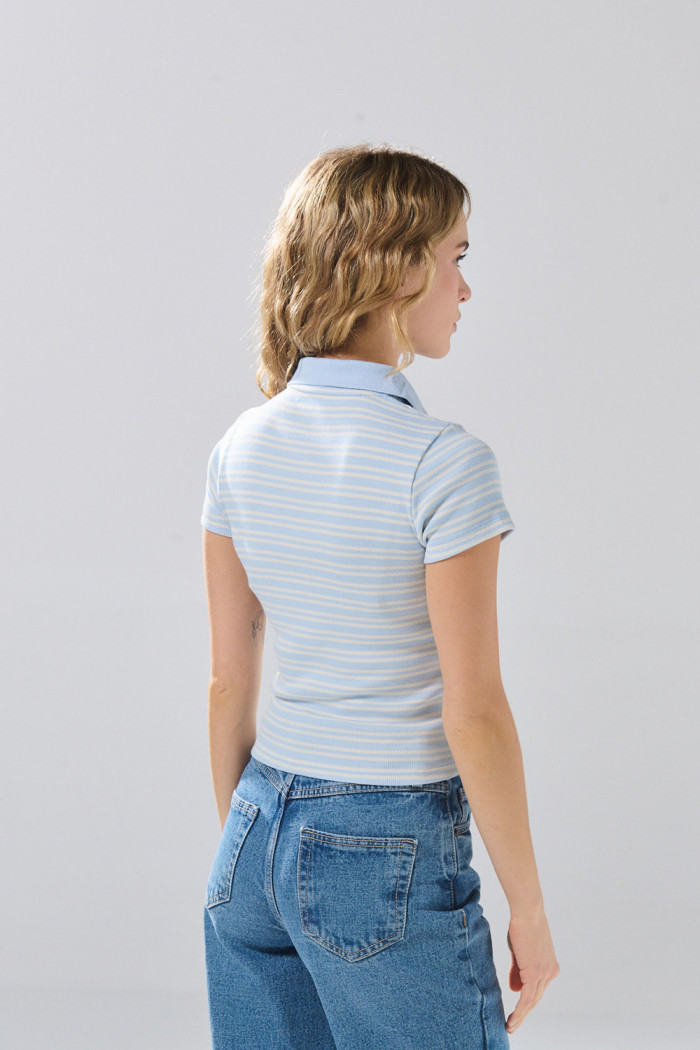 Camiseta azul clara con cuello polo y diseños de rayas
