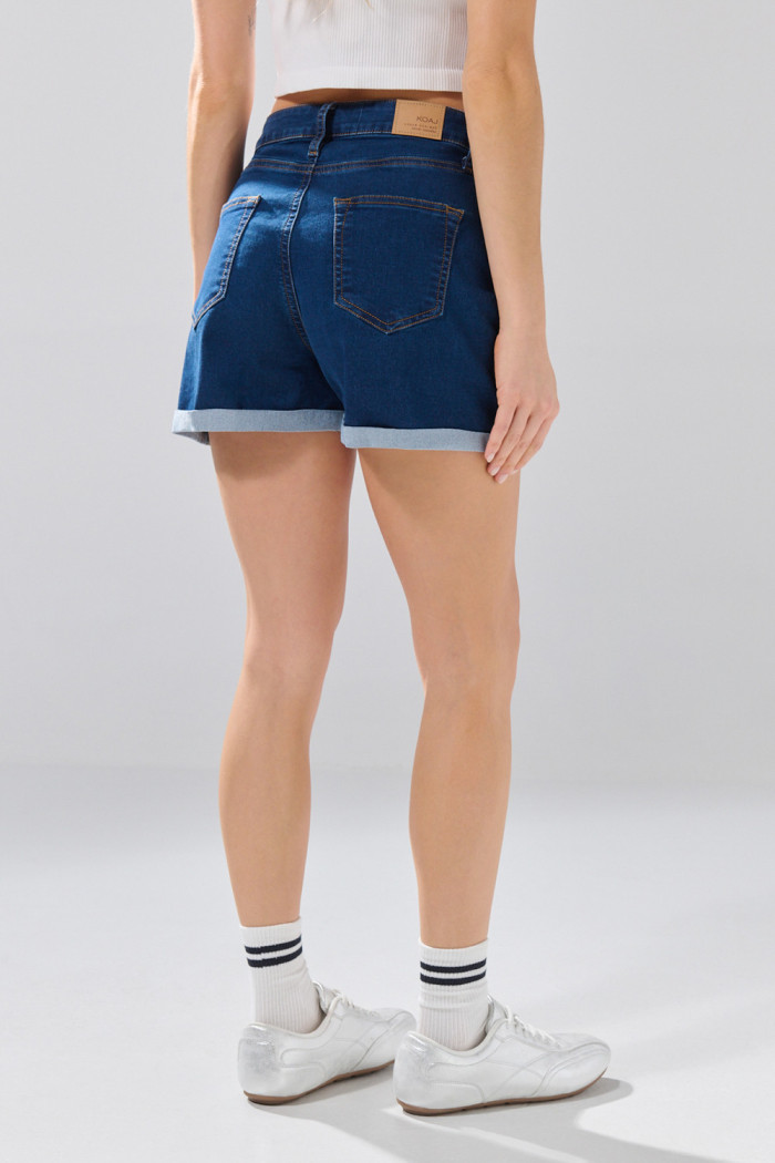 Short de jean azul oscuro con botones visibles y tiro alto
