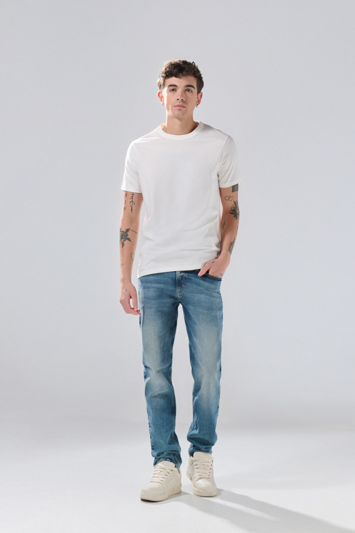Jean azul medio slim 5 bolsillos con tiro bajo y desgastes
