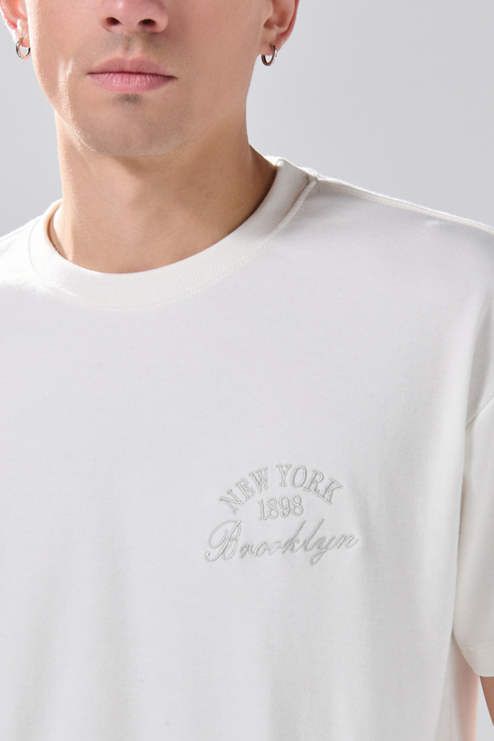Camiseta cuello redondo crema en algodón con arte college
