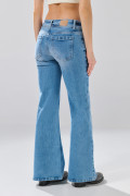 Jean flare azul claro con bota ancha y ligeros desgastes
