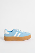 Tenis casuales unicolores con contrastes y suelas altas.