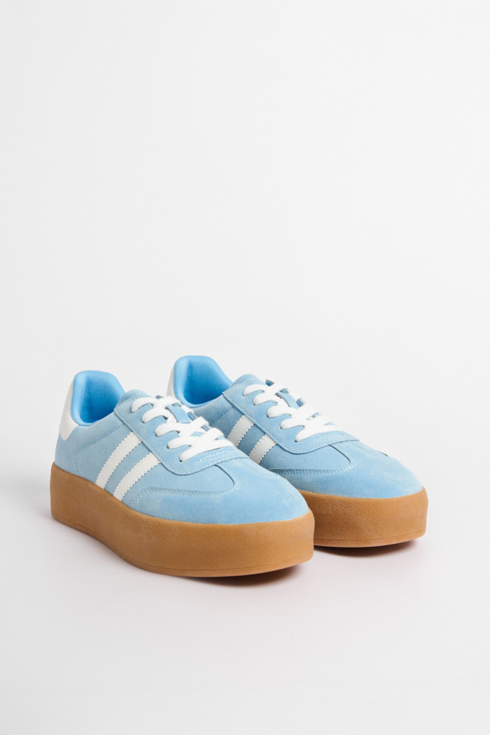 Tenis casuales unicolores con contrastes y suelas altas.