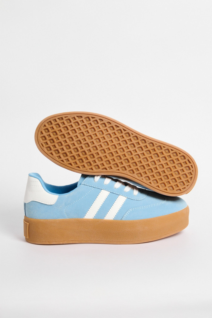 Tenis casuales unicolores con contrastes y suelas altas.