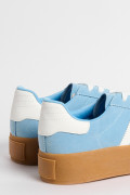 Tenis casuales unicolores con contrastes y suelas altas.