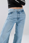 Jean tiro medio baggy con bota ancha azul claro y desgastes
