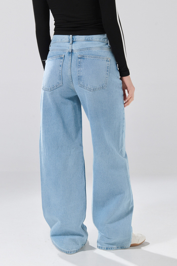 Jean tiro medio baggy con bota ancha azul claro y desgastes
