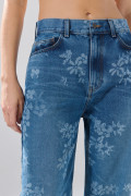 Jean azul medio loose con bota recta y diseños de flores
