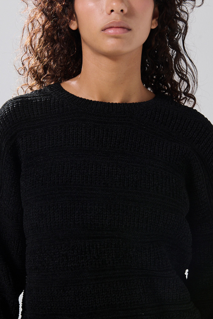 Suéter negro tejido con texturas y cuello redondo
