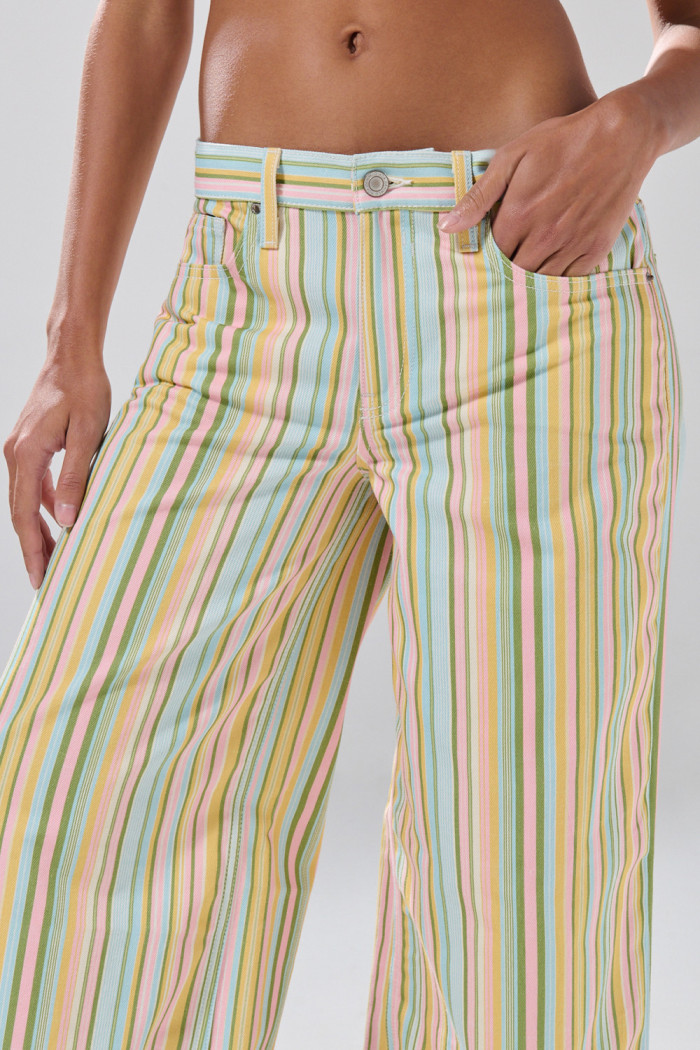 Jean open leg crema claro con rayas coloridas y bota ancha
