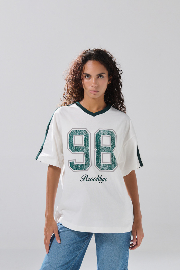 Camiseta crema oversize cuello V con estampado college

