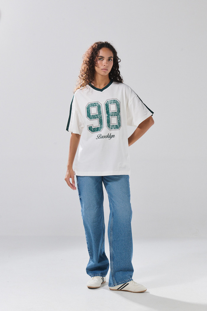 Camiseta crema oversize cuello V con estampado college
