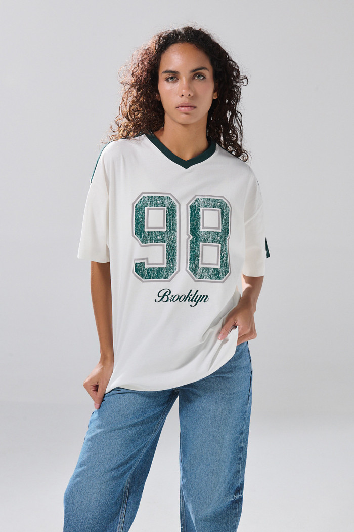 Camiseta crema oversize cuello V con estampado college
