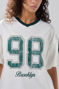 Camiseta crema oversize cuello V con estampado college
