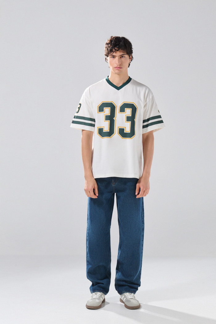 Camiseta crema cuello V oversize con artes college numéricos
