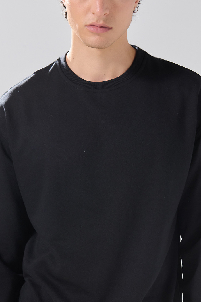 Buzo oversize cuello redondo unicolor en tela perchada
