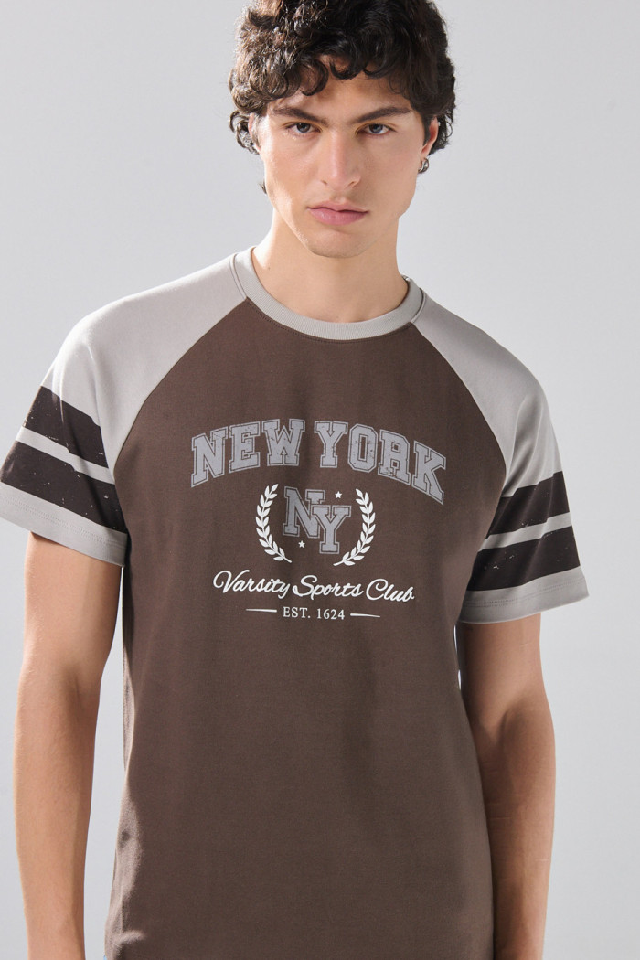 Camiseta manga ranglan corta café oscura con arte college
