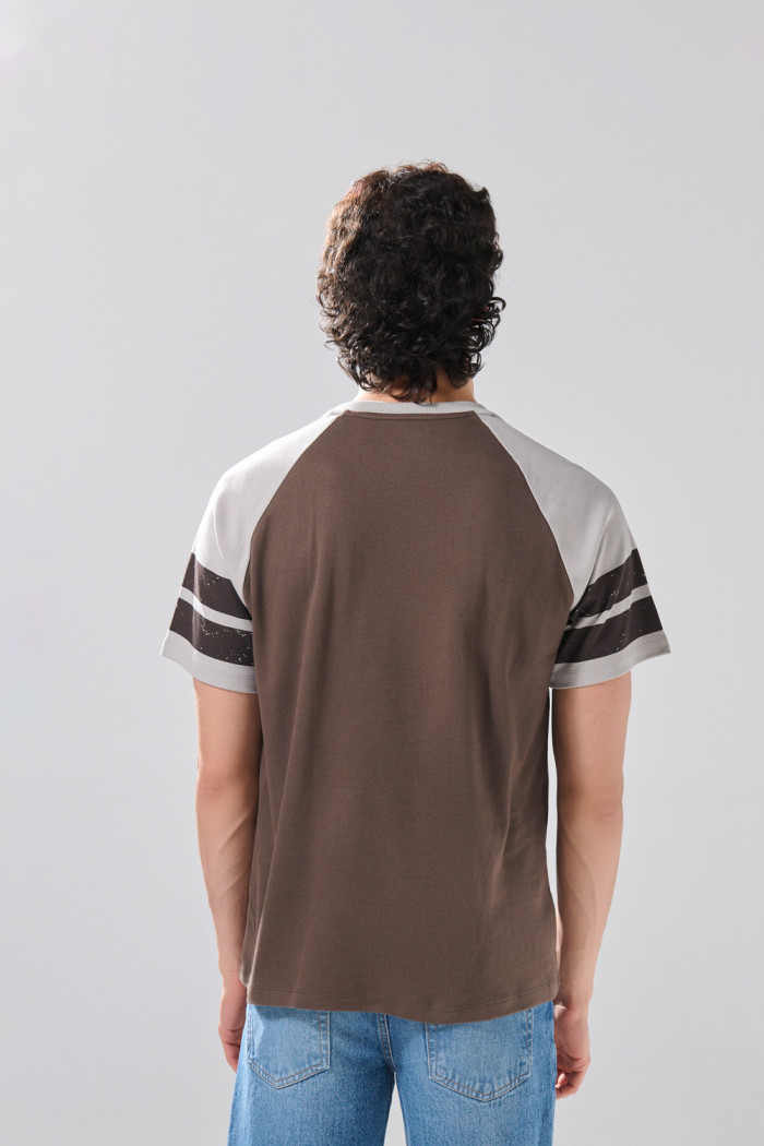 Camiseta manga ranglan corta café oscura con arte college
