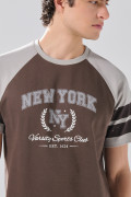 Camiseta manga ranglan corta café oscura con arte college
