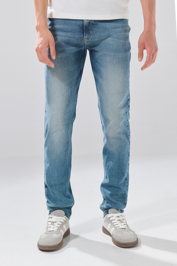Jean slim infaltables azul medio con desgastes y bolsillos
