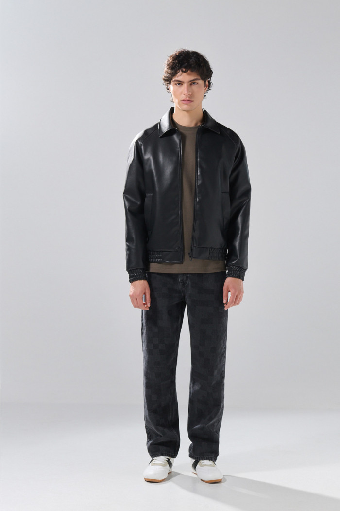 Chaqueta cuello trucker negra en PU con manga ranglan

