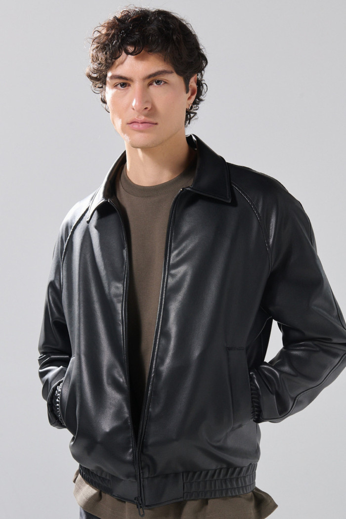 Chaqueta cuello trucker negra en PU con manga ranglan
