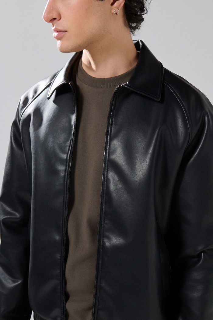 Chaqueta cuello trucker negra en PU con manga ranglan
