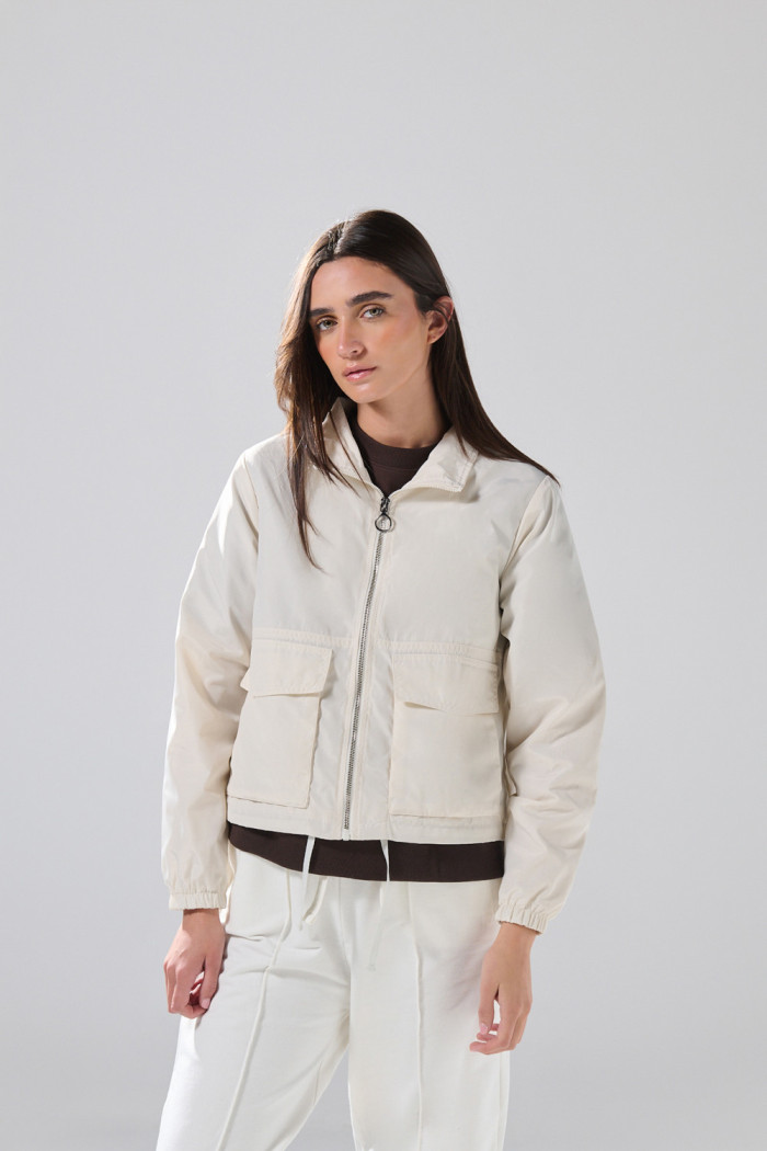 Chaqueta crop liviana negra con cuello alto y bolsillos