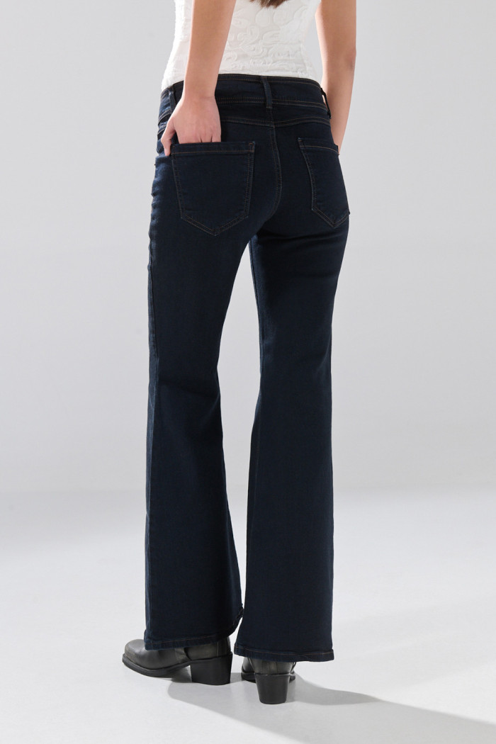 Jean flare azul intenso con bota ancha y bolsillos de parche
