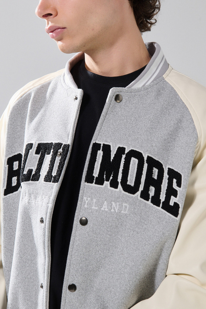 Chaqueta gris bomber con arte college y mangas en PU