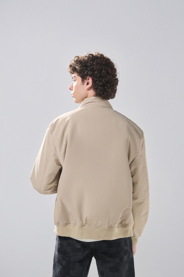 Chaqueta unicolor bomber con cuello alto y broches