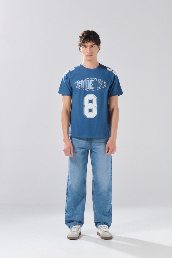 Camiseta azul con manga ranglan y diseños college
