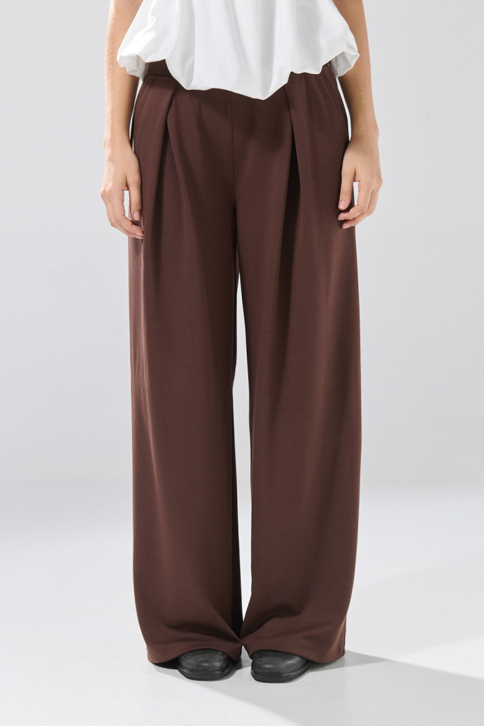 Pantalón unicolor jogger con bota ancha y prenses
