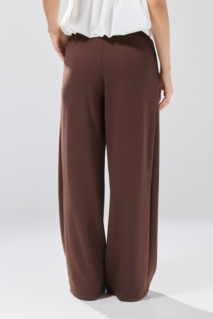 Pantalón unicolor jogger con bota ancha y prenses
