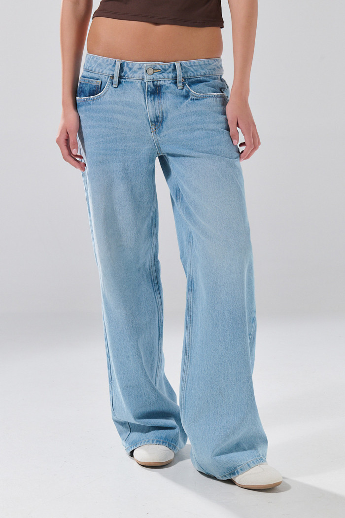 Jean open leg infaltables azul claro con bota ancha y botón
