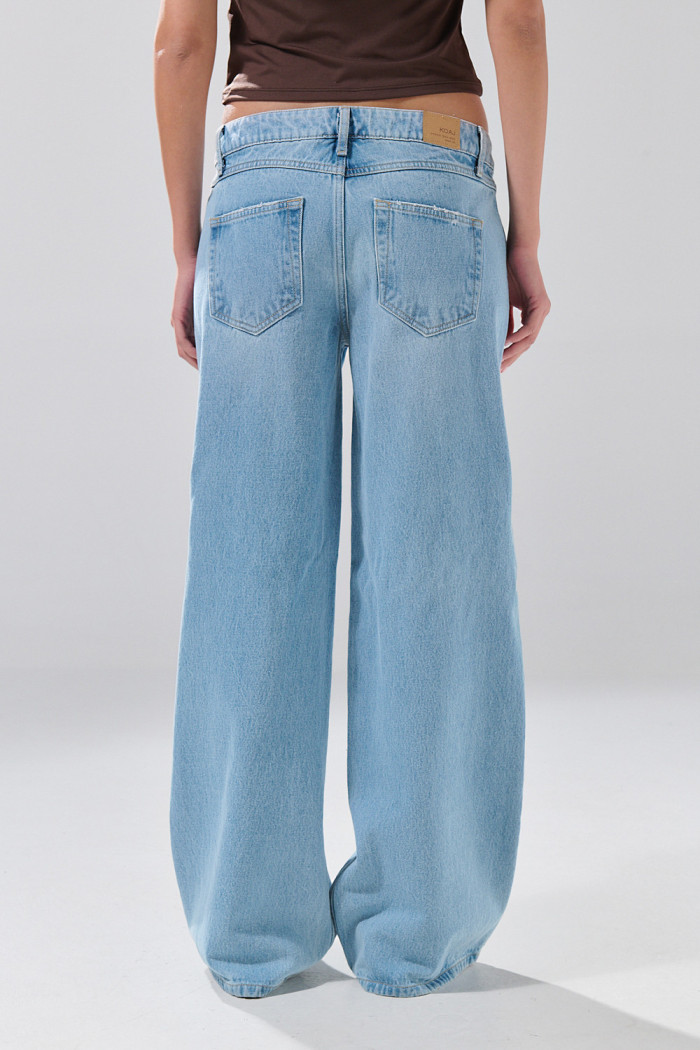 Jean open leg infaltables azul claro con bota ancha y botón
