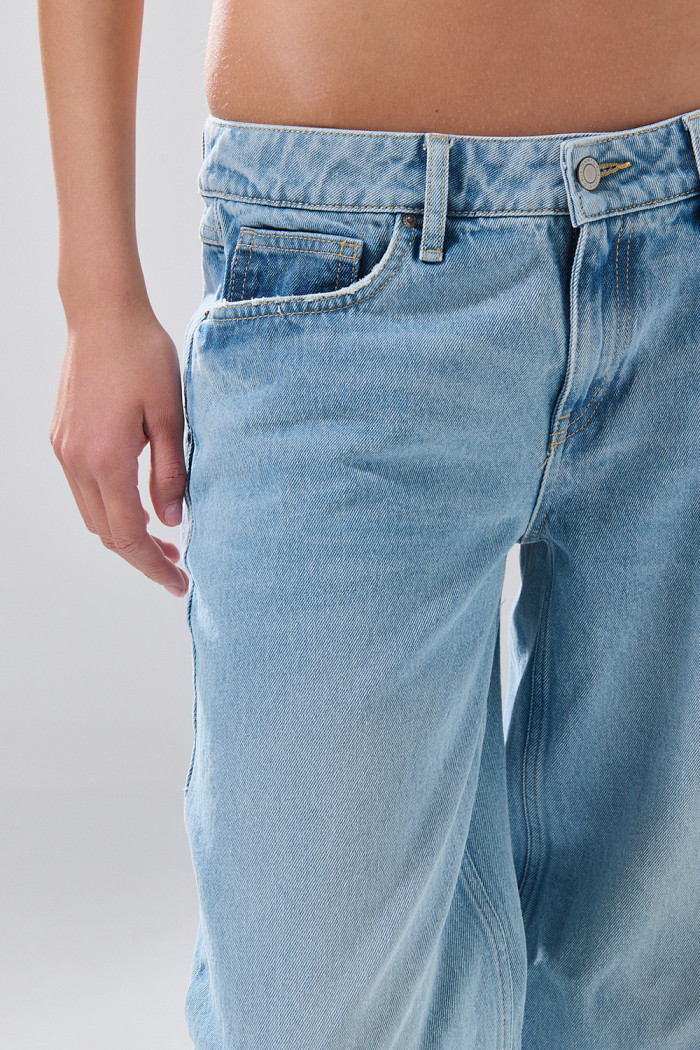 Jean open leg infaltables azul claro con bota ancha y botón
