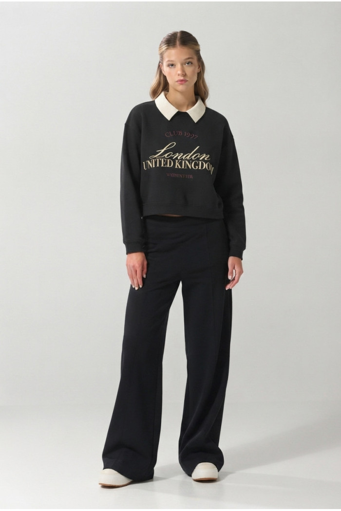 Buzo negro con cuello polo y estampado college en frente
