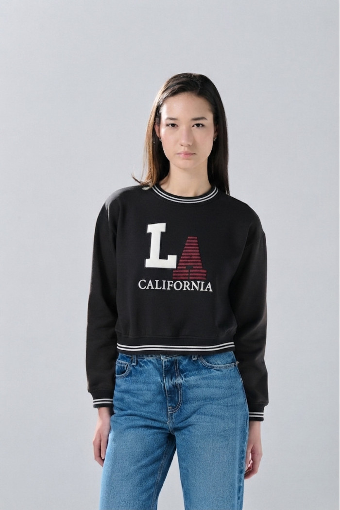 Buzo oversize negro college cuello redondo con manga ranglan
