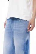 Jean azul claro loose con cortes, bota ancha y tiro medio
