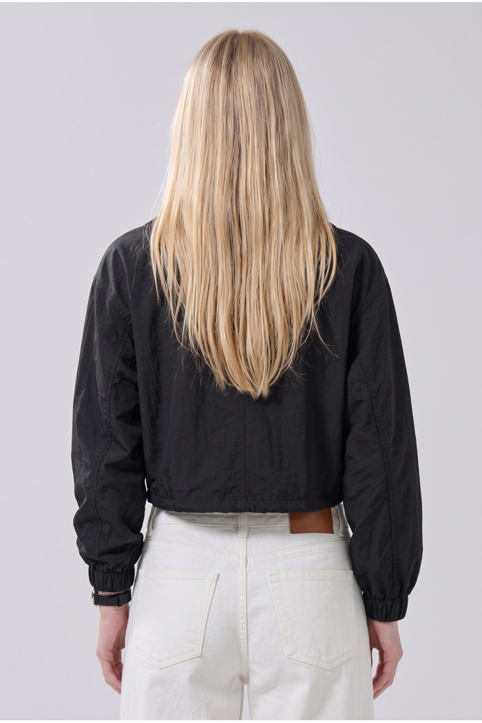 Chaqueta crop liviana negra con cuello alto y bolsillos