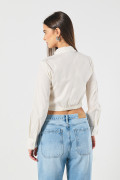 Blusa unicolor crop top con manga larga y cuello camisero