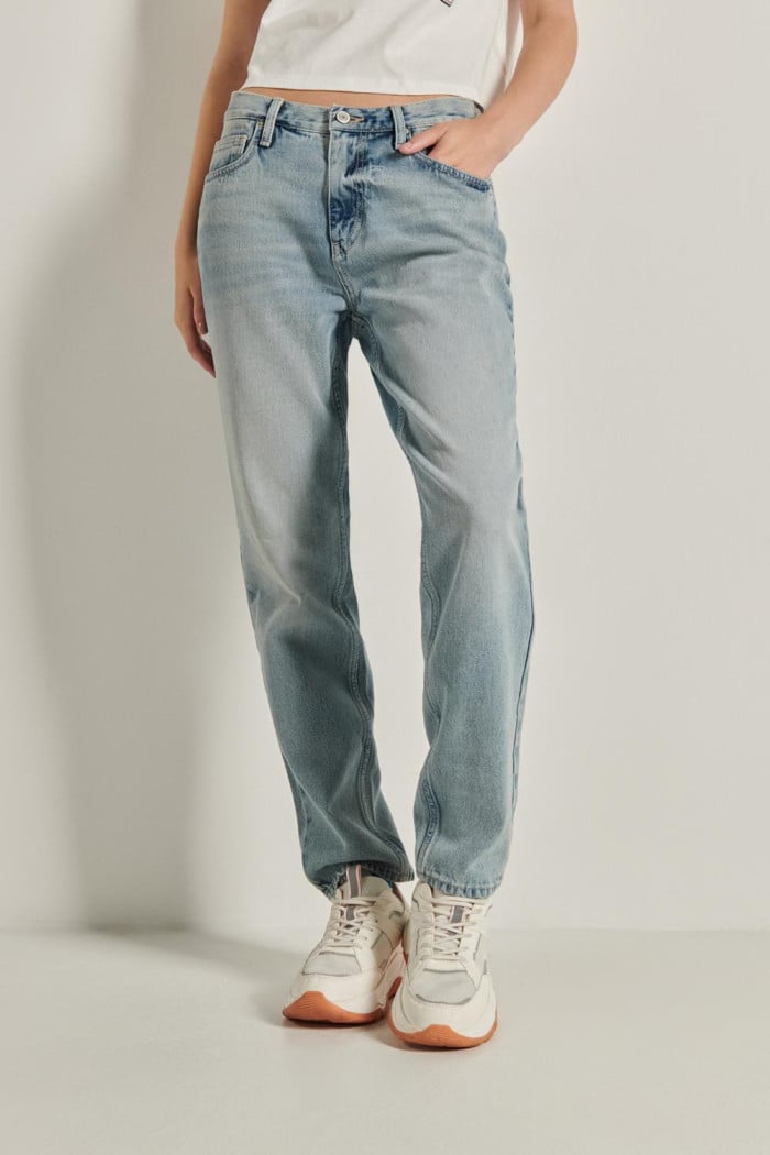 Jean tiro alto boyfriend azul con desgastes y bota recta