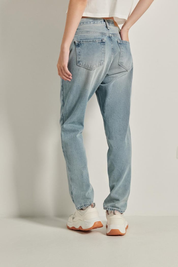 Jean tiro alto boyfriend azul con desgastes y bota recta
