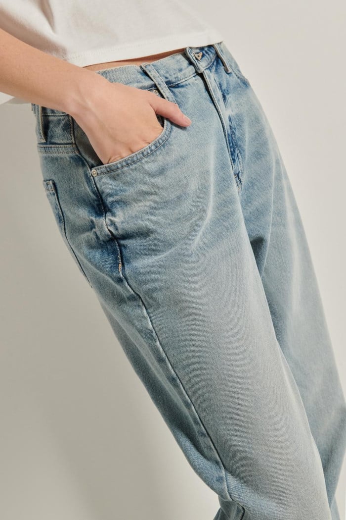Jean tiro alto boyfriend azul con desgastes y bota recta