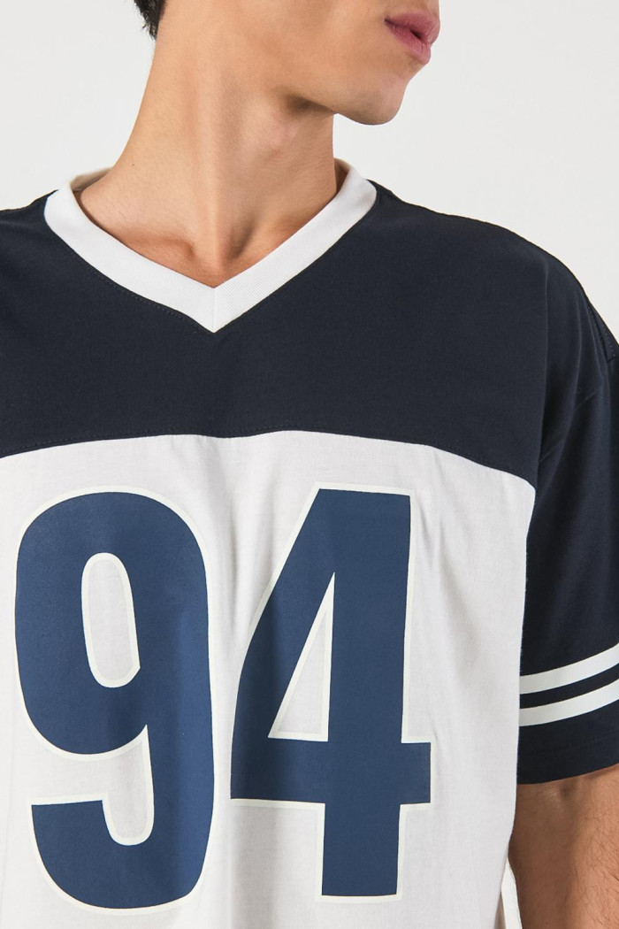 Camiseta crema oversize con diseños college y cuello V