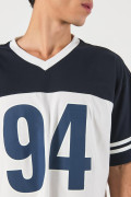 Camiseta crema oversize con diseños college y cuello V