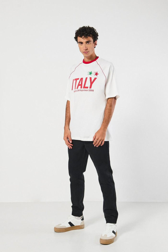 Camiseta oversize crema con diseños college y cuello redondo